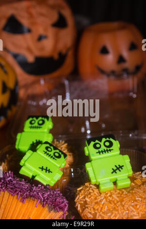 Halloween Party Kürbis Laternen, Kerzen und Cupcakes mit Zombie-Dekorationen. Stockfoto