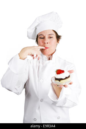 Hübsche Konditor in Kochs weißen Verkostung eine köstliche Schokoladen-Käsekuchen-Tarte mit Schlagsahne und ein Sahnehäubchen.  Isola Stockfoto