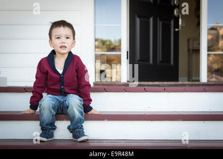 Süße Melancholie Mischlinge Junge sitzt auf der Veranda Schritte. Stockfoto