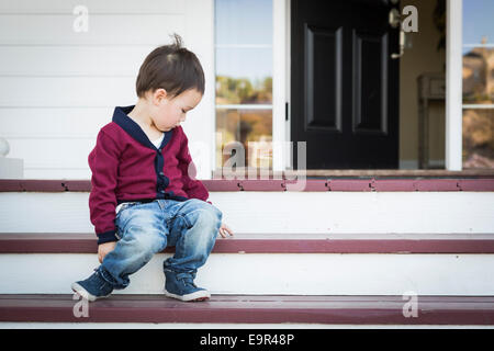 Süße Melancholie Mischlinge Junge sitzt auf der Veranda Schritte. Stockfoto