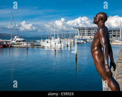 Max Patte Statue Trost des Windes, Bronzefigur, beugte sich über den Hafen in der Nähe der Marina im Hafen von Wellington, Neuseeland Stockfoto