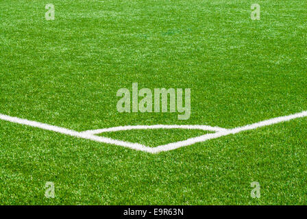 Weiße Ecke Liniensymbol auf grünen Rasen-Sportplatz. Stockfoto