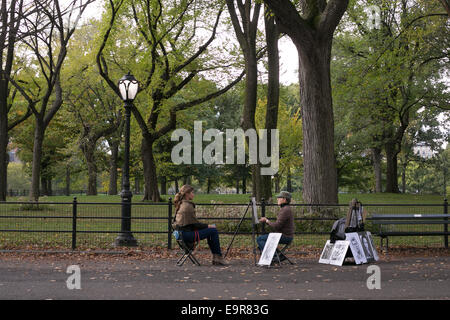 Eine Frau sitzt für ein Porträt Zeichnung entlang der Mall im Central Park in New York City. Stockfoto