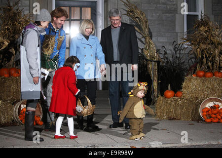 Ottawa, Kanada. 31. Oktober 2014. Kinder in Kostümen und ihre Eltern warten, um Kanadas Premierminister Stephen Harper an seinem 24 Sussex Wohnsitz während Halloween-Feierlichkeiten in Ottawa, Kanada, am 31. Oktober 2014 grüßen. Premierminister Harper und seine Frau Laureen ausgehändigt behandelt den Kindern als benutzerdefinierte an Halloween. Bildnachweis: Cole Burston/Xinhua/Alamy Live-Nachrichten Stockfoto