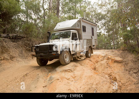 Unique-Land Rover Wohnmobil getrieben auf grobe / erodierten Abschnitt Feldweg durch Wald im Australian National park Stockfoto