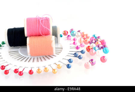 Perlen, Pin, Fäden Zubehör auf weißem Hintergrund Stockfoto