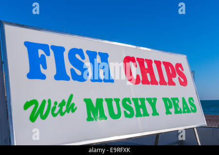 Ein bunten und Fett Zeichen Werbung Fisch, chips mit Erbsenpüree am Strand von Brighton Stockfoto