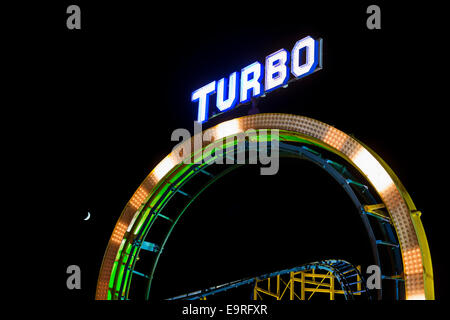 Beleuchtete "Turbo" Zeichen auf einer Schleife von einer Achterbahn in der Nacht Stockfoto