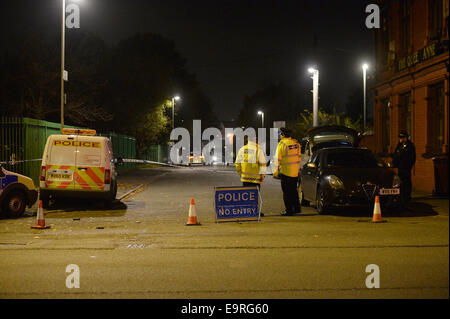 Openshaw, Manchester, UK. 31. Oktober 2014. Polizei haben eine Mord Anfrage ins Leben gerufen, nachdem ein Mann an Schussverletzungen in Manchester starb.  Das Opfer wurde gefunden mit Schussverletzungen in der Nähe von Manchester Lebensmittelhandel auf Wood Street in Openshaw zusammengebrochen. 31. Oktober 2014. Bildnachweis: Alamy Live-Nachrichten Stockfoto