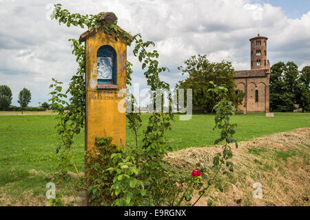 Votiv AEDI-gewidmet der Heiligen Jungfrau Maria in der Nähe der mittelalterlichen Landschaft Kirche Campanile mit romanischen zylindrische Glockenturm, befindet sich in der Ortschaft Santa Maria in Fabriago in der Region Emilia-Romagna in Norditalien Stockfoto