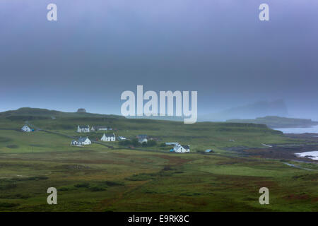 Malerische weiß getünchten Croft Ferienhäuser im Weiler eingebettet von der Küste an einem nebligen Grau Himmel-Tag auf der Isle Of Skye, Western Isles Stockfoto