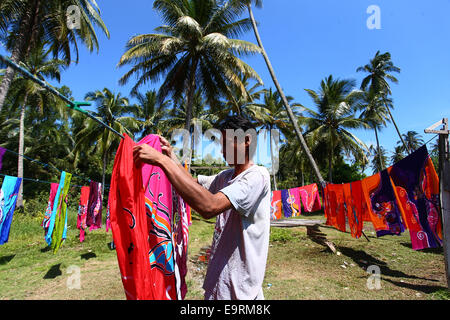 Handwerksmeister Trocknung Batik Kunsthandwerk, manuell von Hand unter der tropischen Sonne gemalt. Stockfoto