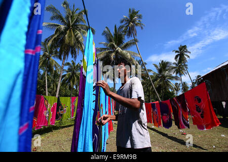 Handwerksmeister Trocknung Batik Kunsthandwerk, manuell von Hand unter der tropischen Sonne gemalt. Stockfoto