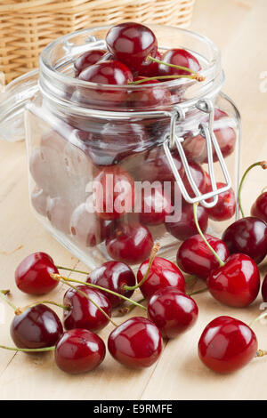 rote Kirschen im Glas auf Küchentisch Stockfoto