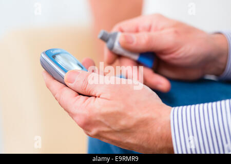 Mann mit Altersdiabetes Messung des Blutzuckers mit Indikator Stockfoto