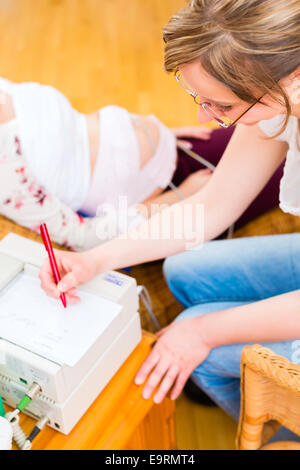 Hebamme, Prüfung Bauch der Schwangeren mit CTG Scannen in der Praxis Stockfoto