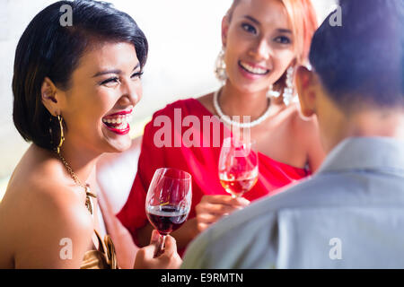 Asiatische Freunde Weintrinken in schicke bar Stockfoto