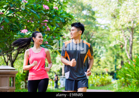 Asiatische chinesische Mann und Frau im Stadtpark Joggen Stockfoto