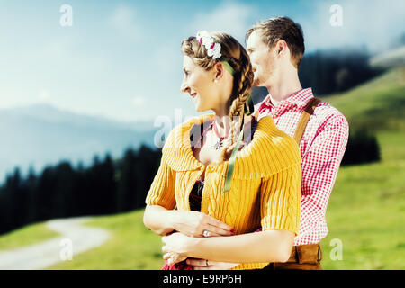 Paar in Tracht auf Alp Berggipfel im Urlaub Stockfoto