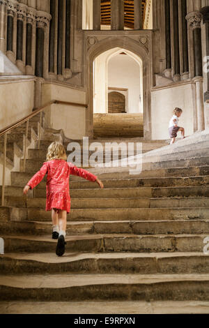 Touristischen Mädchen auf Steintreppen Wells Cathedral; Schritte führen zu das Kapitelhaus / Kapitelsaal. Wells, Somerset. UK