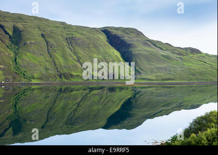 Berghängen reflektiert in den Gewässern von einem Loch auf Isle Of Skye in den Highlands und Inseln Schottlands Stockfoto