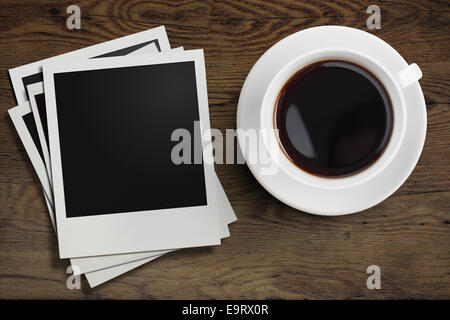 Kaffee Tasse und Polaroid-Foto-Rahmen auf hölzernen Tischplatte anzeigen Stockfoto