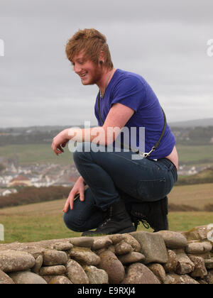 Young Adult Mann auf einem Knie, Bude, Cornwall, UK Stockfoto