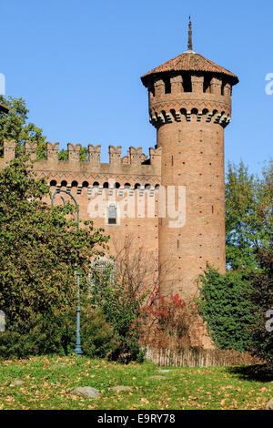 Der Turm der mittelalterlichen Burg im Valentino Park, Turin (Italien), umgeben von Vegetation vor dem Hintergrund des blauen Himmels Stockfoto