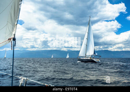 Segelschiff Yachten mit weißen Segeln im Meer bei stürmischem Wetter. Stockfoto