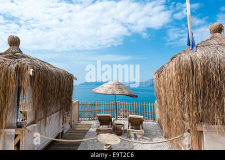 Strandhütten, Sonnenschirm und Liegestühle vor schönen Meer Stockfoto