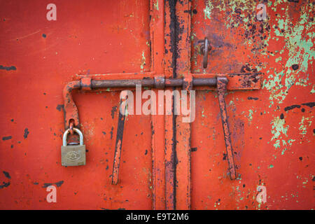 Rote Tür mit einer Schraube und einem Vorhängeschloss Stockfoto