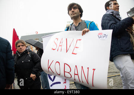 Oslo, Norwegen. 1. November 2014. Ein Mann hält ein Schild mit der Aufschrift "Kobani speichern" als kurdische Flüchtlinge und ihre Anhänger überschwemmen Oslos Youngstorget Plaza als Teil des globalen Rallyes in Solidarität mit den belagerten syrischen Stadt Kobani, der der Westen unterstützte Krieg gegen die Aufständischen islamischer Staat, 1. November 2014 geworden ist. Bildnachweis: Ryan Rodrick Beiler/Alamy Live-Nachrichten Stockfoto