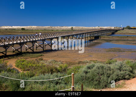 Die längste Holzbrücke in Europa kreuzt nach Praia do Gigi, im Naturpark Ria Formosa, Quinta do Lago, Algarve, Portugal. Stockfoto