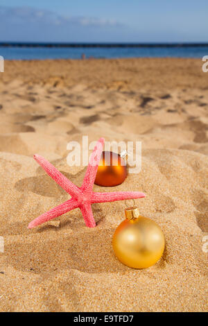 Weihnachtskugeln mit Seestern am Strand Stockfoto