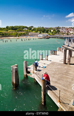 Ein einsamer Fischer versucht sein Glück von der restaurierten viktorianischen Pier an der Jurassic Coast in Swanage Dorset England UK Stockfoto