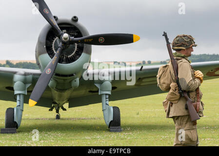 Duxford, Großbritannien - 13. Juli 2014: Soldat bewacht Oldtimer-Flugzeuge Stockfoto