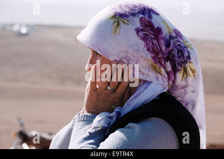 Eine kurdische Frau wacht die alliierten Luftangriffe in Kobani, von einem Hügel an der türkisch-syrischen Grenze, die mit Blick auf die Stadt, Türkei Stockfoto