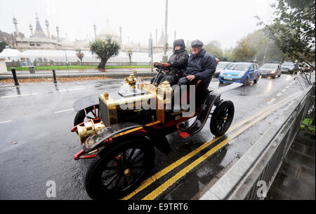 Brighton, UK. 2. November 2014. Fahrer und Passagiere im berühmten Genevieve Auto trotzen die schrecklich nasse und windige Wetter in Brighton am Ende der Reise an der Bonhams London, Brighton Veteran Car Run heute The Run findet am ersten Sonntag jeden November eintreffen und ist die am längsten laufende Ereignis in der Welt Genevieve Autofahren aus dem Jahr 1953 britische Film mit dem gleichen Namen bekannt wurde und spricht 1904 Darracq 12hp. : Live-Nachrichten Simon Dack/Alamy Stockfoto