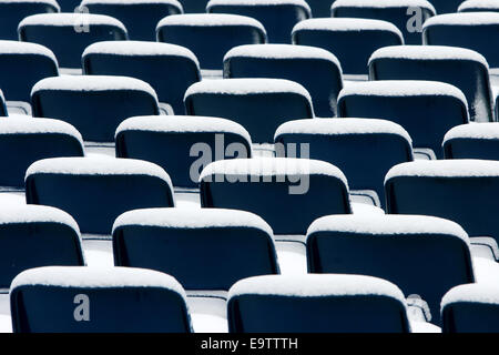 Leere Plastikstühle in Reihen mit Schnee bedeckt. Stockfoto