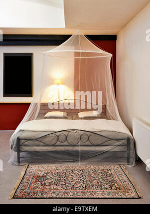 COSI Vintage Bett mit Moskitonetz in einem restaurierten loft Stockfoto