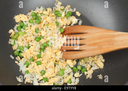 Nahaufnahme von Ei gebratener Reis in einer Antihaft-Pfanne mit einem Holzspatel Stockfoto