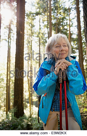 Heitere senior Frau Wandern im sonnigen Wald