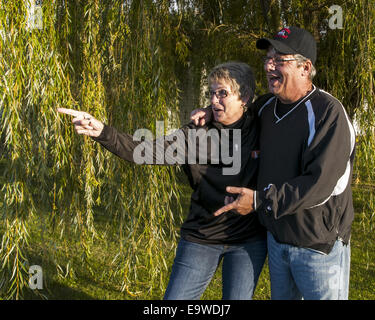 Ein Mann und eine Frau stehen vor einem Baum Trauerweide. Stockfoto