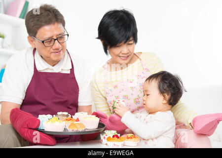 Asiatischen Familie backen, Kuchen, Großeltern und Enkel indoor Living Lifestyle zu Hause. Stockfoto