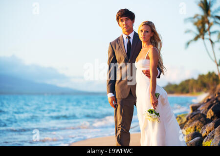 Schöne Hochzeitspaar, Braut und Bräutigam am Strand bei Sonnenuntergang Stockfoto