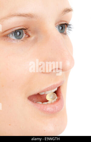 Junge Frau mit einer Pille zwischen den Zähnen Stockfoto