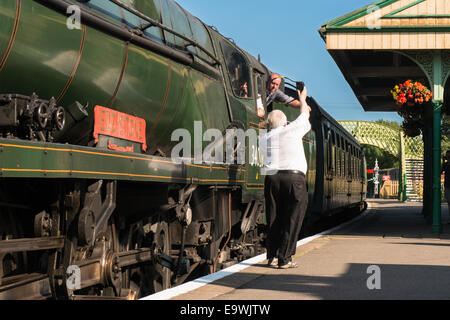 Eisenbahner und Lokführer tauschen die Sicherheit Token vor Dampfmaschine Zug, "Eddystone" fährt Corfe Castle station Stockfoto