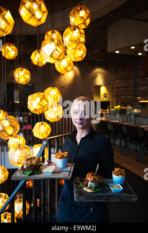 Grillmarkadurinn Restaurant in Reykjavik, Island. Kellner, Burger von Tom Dixon Anhänger serviert. Stockfoto