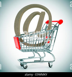 ein at-Zeichen in einem Warenkorb, zeigt das Konzept der e-shopping oder e-Commerce Stockfoto