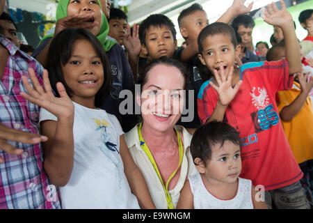 Jakarta, Indonesien. 3. November 2014. Actress Natalia Woerner (C) posiert mit ehemaligen Strassenkindern in Jakarta, Indonesien, 3. November 2014. Sie unterstützt die Kindernothilfe, eine deutsche Hilfsorganisation für Kinder, welche ein Kinderdorf in Jakarta wo Kinder einfache Aufgaben Services lernen wie das Waschen und kochen. Laut des indonesischen Ministeriums für soziale Angelegenheiten Leben mehr als 11.000 Kinder auf der Straße in Jakarta. Foto: MAURIZIO GAMBARINI/Dpa/Alamy Live News Stockfoto